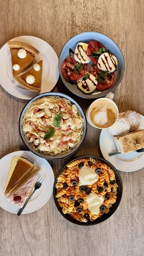Flat lay of pumpkin pie, caprese salad, chicken pasta, cappuccino and cheesecake at Wish Delish