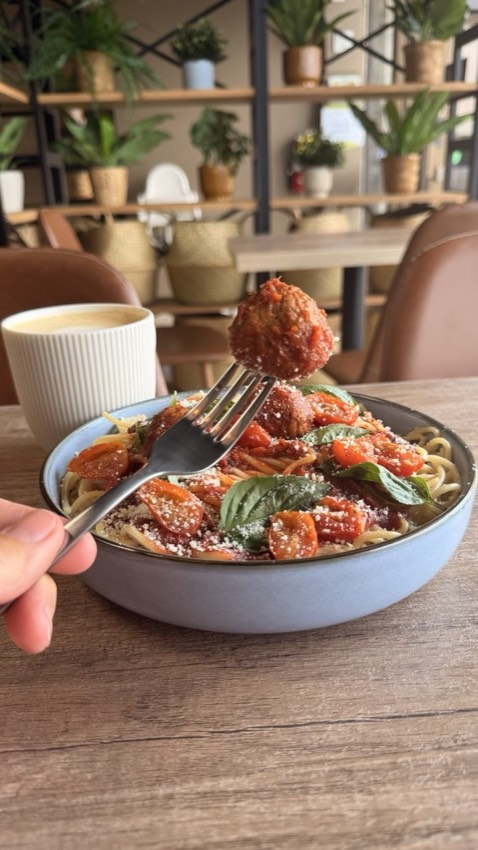 Spaghetti and meatballs served with a cup of coffee at Wish Delish