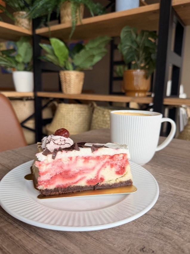 Cheesecake slice with berry swirl and chocolate shavings at Wish Delish