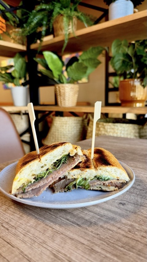 Grilled panini sandwich with meat and greens at Wish Delish Cafe-Bistro