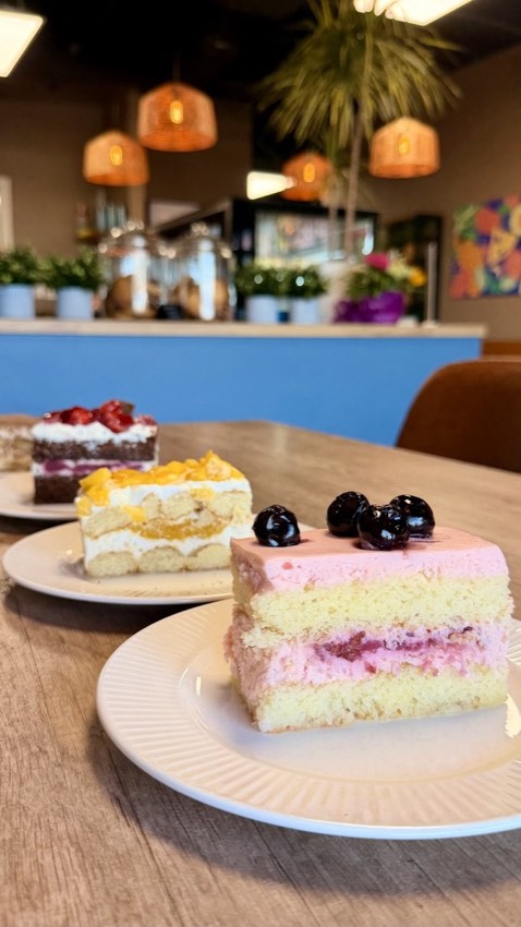 Assorted cake slices including chocolate berry cake and mango layered cake at Wish Delish